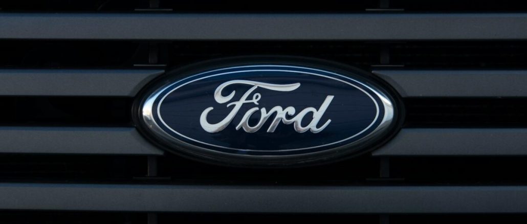 Detailed view of a Ford emblem mounted on a vehicle grille, showcasing modern design.