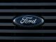 Detailed view of a Ford emblem mounted on a vehicle grille, showcasing modern design.